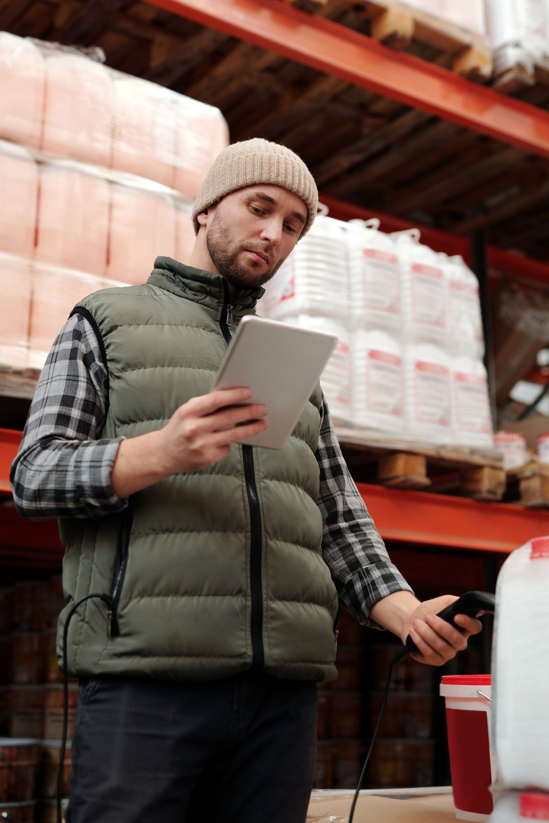 A logistics employee reviewing inventory inside a distribution warehouse