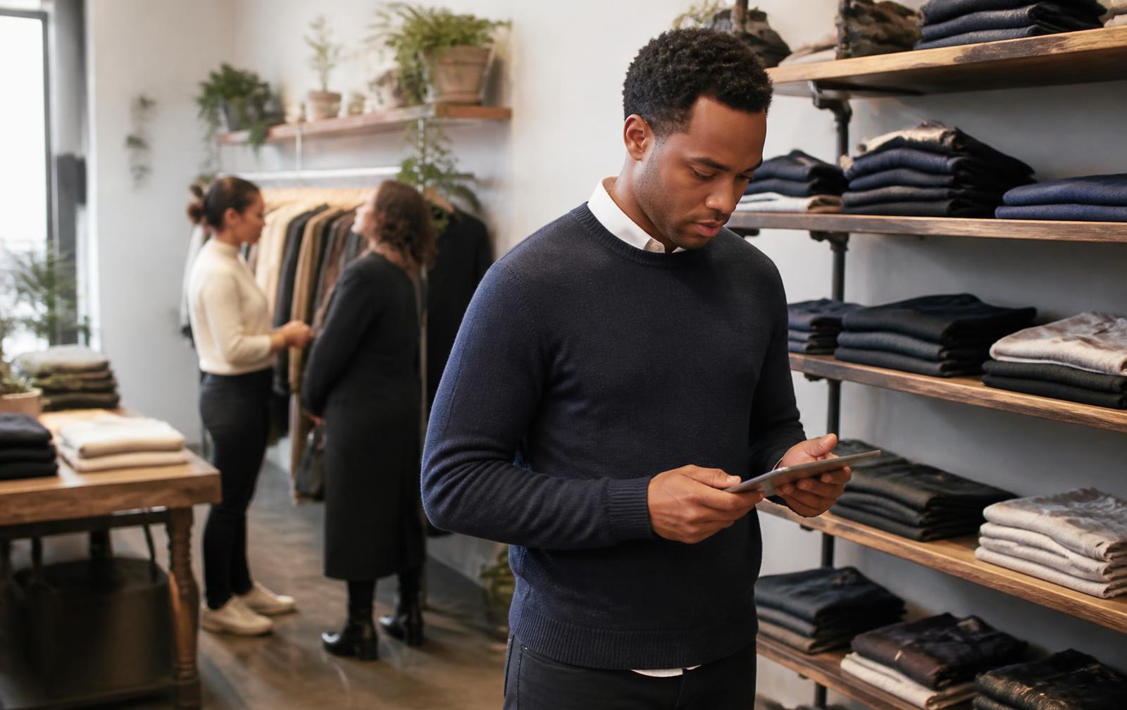 A store manager checking stock on a handheld device in a modern retail store
